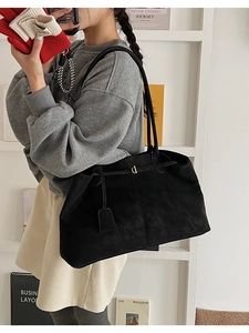 Détail du grand sac cabas en daim noir mat avec boucle dorée et fines lanières