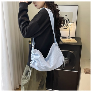Détail du sac à bandoulière en nylon bleu clair avec un design élégant à cordon plissé