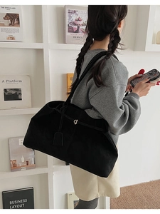 Gros plan d'un grand sac fourre-tout noir en daim avec boucle dorée pour femme