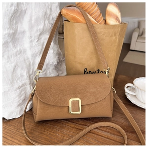 Detail der karamellfarbenen Wildleder-Klapptasche mit Goldverschluss in französischem Stil