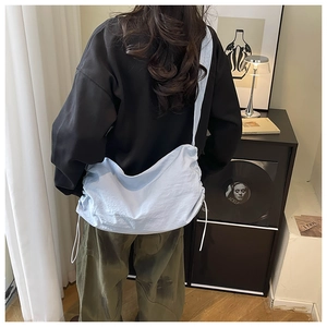 Vue détaillée du sac bandoulière en nylon bleu clair avec plis à cordon élégants