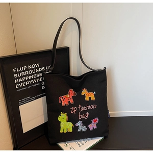 Detailed view of colorful embroidered horse patches on a black canvas tote bag