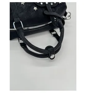 Detail of black leather bag with silver star rivets and reinforced handle stitching