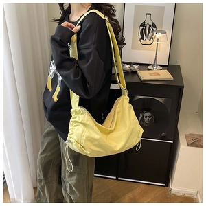 Détail d'un sac besace en nylon jaune imperméable avec bandoulière réglable et cordon