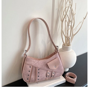 Close-up of pink punk saddle bag with silver metal eyelets and decorative buckles