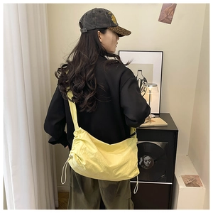 Détail du sac bandoulière en nylon imperméable jaune vif avec sangle noire réglable