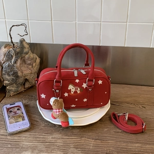 Detail of red suede pillow bag with horse embroidery and cute bear plush charm