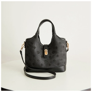 Detail of the black textured handbag showing embossed patterns and golden square swivel lock