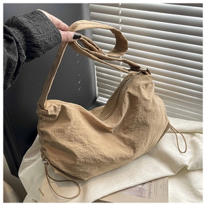 Détail du sac en nylon imperméable kaki avec texture plissée et fermeture éclair robuste