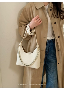 Schicke weiße Schultertasche aus Leder mit Lychee-Muster kombiniert mit hellem Mantel