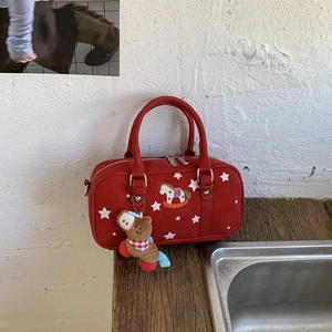 Detail of red pillow bag featuring white star print and horse embroidery with plush charm