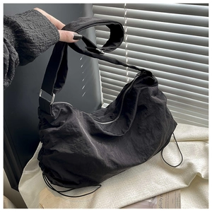 Vue détaillée du sac bandoulière en nylon noir texturé avec détails de plis coulissants