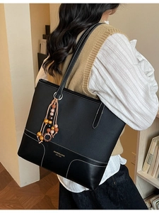 Elegante borsa tote in pelle nera con cuciture bianche a contrasto e nappa con perline