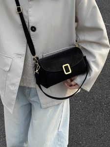 Minimalistische schwarze Baguette-Tasche aus Leder mit goldener Schnalle am Modell