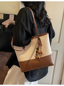 Borsa tote in tela crema con finiture in pelle marrone e ciondolo con nappine