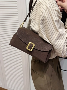 Minimalistische kaffeebraune Wildleder-Schultertasche mit goldener Schnalle am Model
