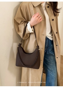 Detail der dunkelbraunen Halbmond-Tasche mit Kieselleder-Struktur und Metallkette