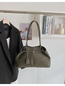 Détail du grand sac cabas vert mousse mat avec boucle dorée sur tenue de bureau