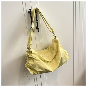 Détail du sac dumpling en nylon imperméable jaune clair montrant la texture plissée et le cordon