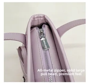 Detail of durable silver metal zipper and large puller on purple bucket handbag