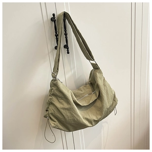 Détail du grand sac croissant en nylon imperméable vert olive avec détails coulissants