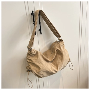 Détail du sac dumpling en nylon imperméable kaki montrant la texture et le cordon de serrage