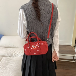 Detail of red pillow bag with rocking horse embroidery and silver hardware
