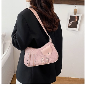 Detail shot of pink saddle bag with distressed faux leather and metal eyelet accents