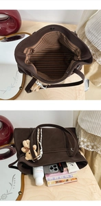 Detailed view of large brown tote bag interior with striped lining and magnetic buckle