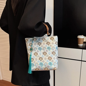 Detail of Chinese style handbag with embroidery, bamboo handle and peacock blue tassel