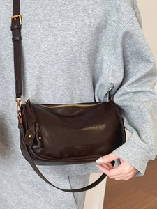 Minimalist dark brown leather shoulder bag with vintage gold hardware and adjustable strap