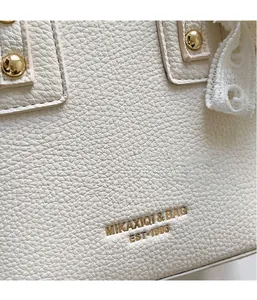 Detail of white lychee leather texture with gold rivets and elegant lace trim