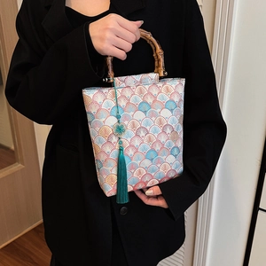 Detail of traditional Chinese jacquard handbag with bamboo handle and green tassel