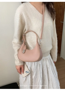 Detail of dusty pink crescent bag showing lychee pattern leather and silver metal buckle
