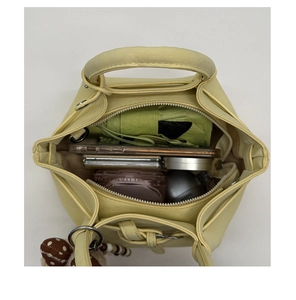 Top view showing the spacious interior of a yellow bucket bag with daily essentials