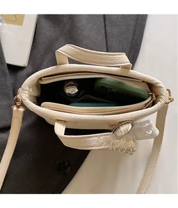 Detail view of cream bucket bag interior space showing large capacity and smooth zipper