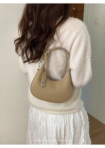 Close-up of beige moon bag with lychee texture and silver metal hardware detail
