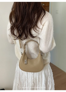 Rear view of model carrying khaki hobo bag with litchi grain and silver buckle