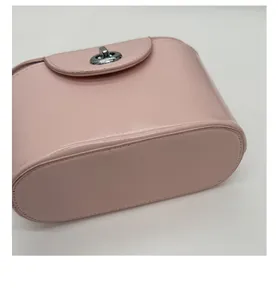 Detailed bottom and side view of the light pink leather handbag with smooth stitching