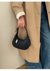 Close-up of black lychee grain leather handbag with silver metallic buckle detail