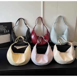 Detail view of colorful glossy patent leather hobo bags in six varied fashion colors