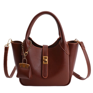 Vintage dark brown tote bag with top handle and bronze twist lock closure on white background