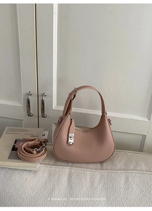 Detailed macro of pale pink hobo bag featuring lychee grain leather and silver lock hardware