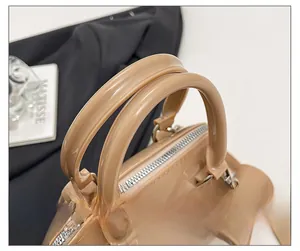 Detail view of smooth brown jelly bag with round handles and silver metal hardware