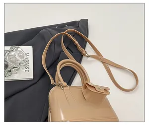 Detail view of beige jelly dome bag with adjustable shoulder strap and mini pouch