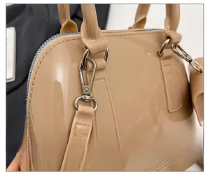 Detailed macro view of silver metal buckles and D-rings on a beige jelly handbag