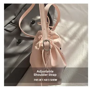 Detailed view of adjustable pink drawstring bucket bag with silver metal buckles