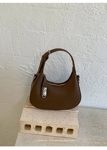 Detail of brown lychee grain leather hobo bag with vintage silver buckle decoration
