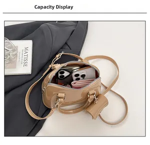 Macro shot of brown patent leather mini bag interior showing capacity for phones and wallet
