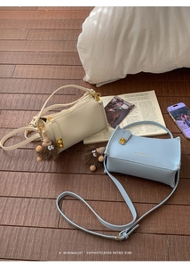 Close-up of leather crossbody bags with golden hardware and plush monster charms